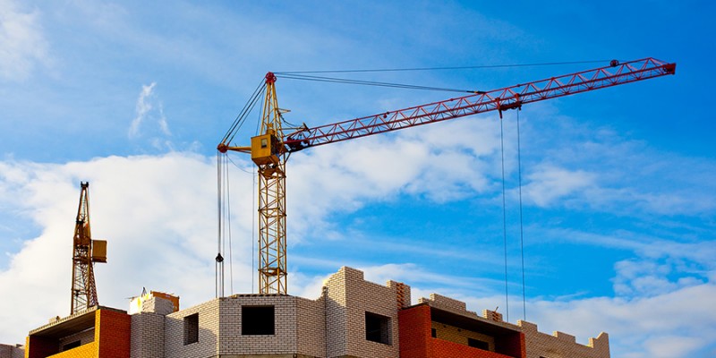 Two cranes and house construction